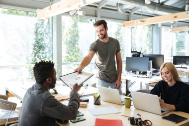 Office coworking oturan gülümseyen genç arkadaşları