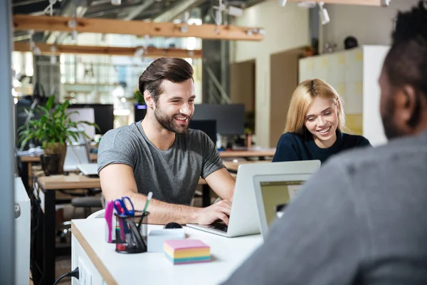 Smilende unge kolleger som sitter i et kontorsamarbeid . – stockfoto