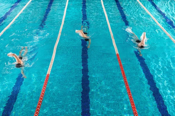 Tre nuotatori maschi che gareggiano l'uno contro l'altro — Foto Stock