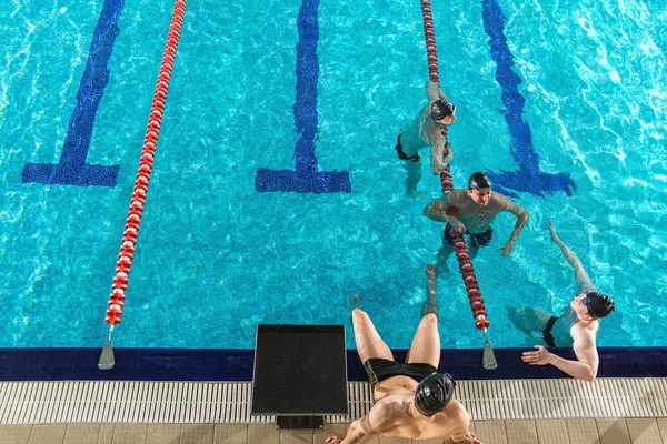 Cuatro nadadores masculinos charlando entre ellos — Foto de Stock