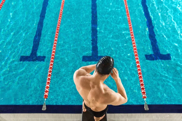 Achteraanzicht van een man die voorbereiding Zwemmen goggles — Stockfoto