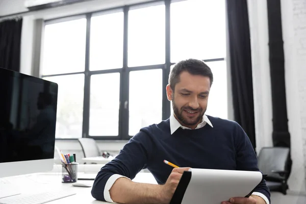 Sonriente joven empresario tomando notas en un bloc de notas —  Fotos de Stock