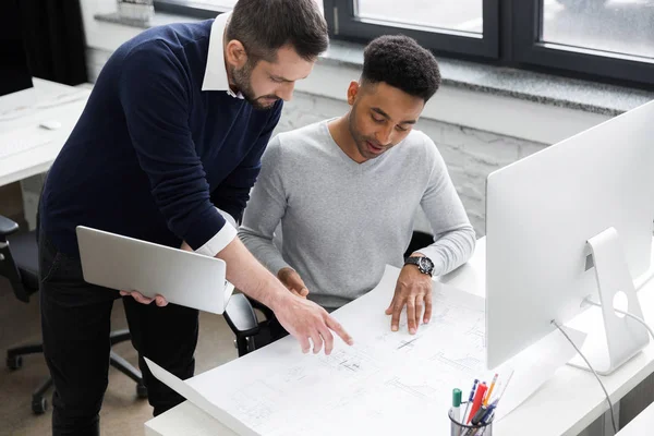 Deux employés de bureau masculins souriants travaillant avec un ordinateur portable — Photo