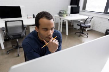 Bilgisayar ekranına bakarak dalgın Afrika iş adamı