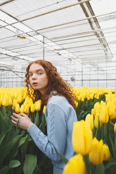 Senhora olhando para longe perto de flores — Fotografia de Stock