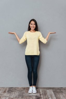 Çekici genç kadın holding boşaltmak her iki avuç içi üzerinde gülümseyen