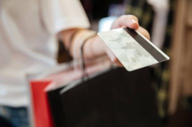 Banka kartı tutan genç kadın Resim kırpılmış.