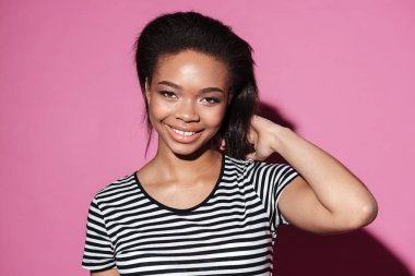 Poz ve kameraya bakarak gülümseyen genç Afrika kadın