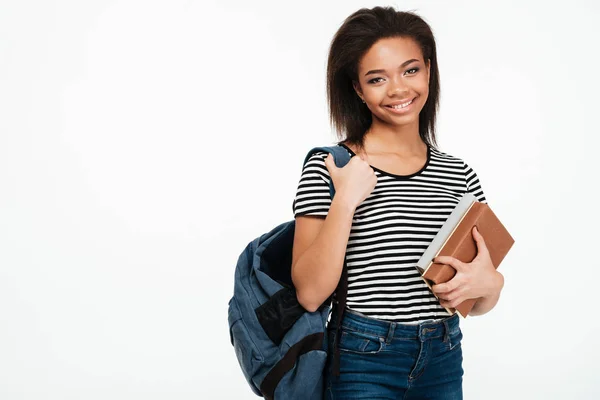 Vrolijk lachende Afrikaanse student meisje dragen rugzak ingedrukt te boeken — Stockfoto