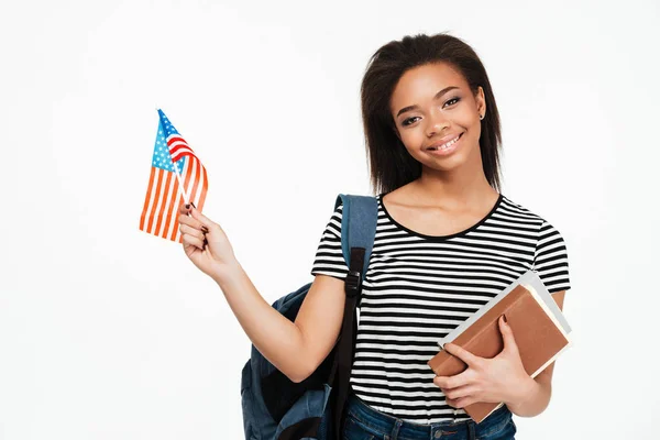 Menina estudante com mochila segurando livros e bandeira dos EUA — Fotografia de Stock