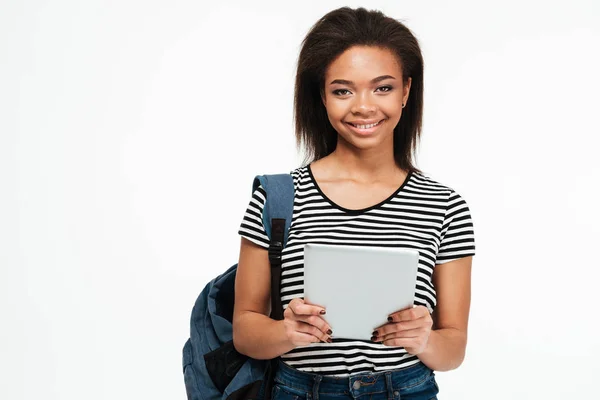 Happy smiling african teenager girl with backpack using pc tablet — Stock Photo, Image