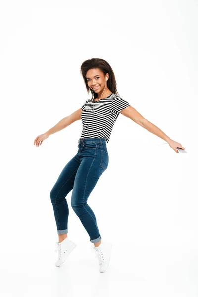 Retrato de comprimento total de uma menina africana despreocupada feliz pulando — Fotografia de Stock