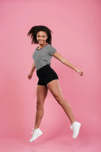 Retrato de longitud completa de una alegre chica africana feliz saltando — Foto de Stock