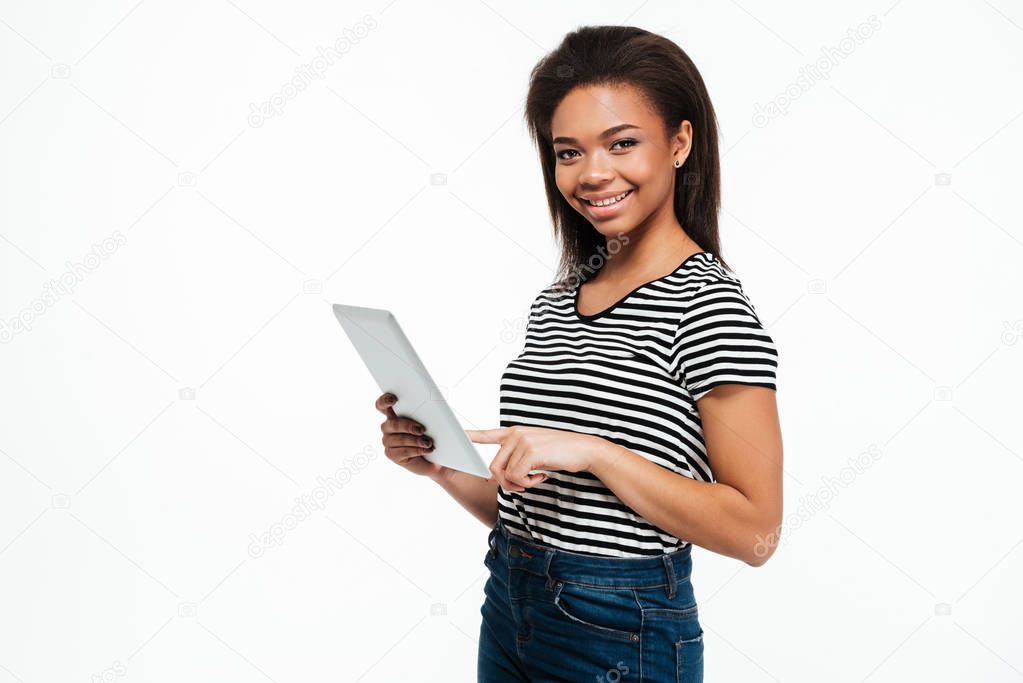 Happy young african woman using tablet computer.