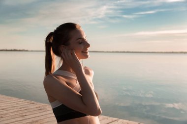 Spor Bayan plaj müzik dinleme, gülümseyen