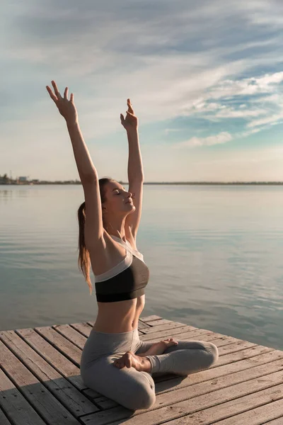 Спортивная леди на пляже делает медитативные упражнения . — стоковое фото