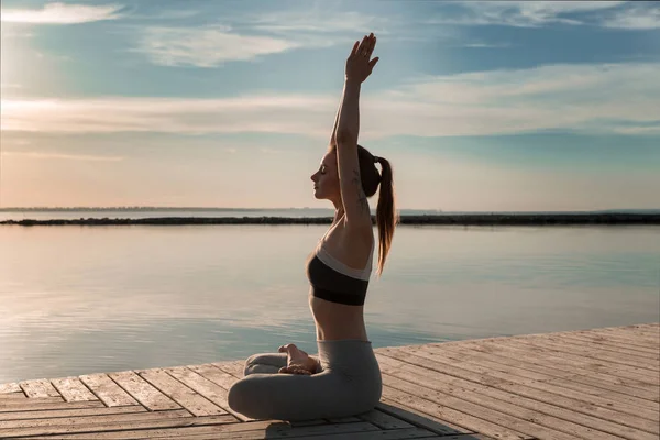Спортивная леди на пляже делает медитативные упражнения . — стоковое фото