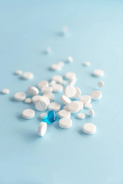 Zbliżenie na białe tabletki z jedna kapsułka niebieski — Zdjęcie stockowe