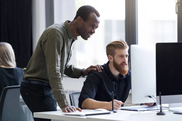 Dos jóvenes hombres de negocios trabajando juntos en una computadora — Foto de Stock