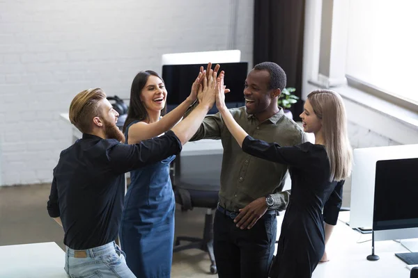 Group of young colleagues giving each other a high five — Stock Photo, Image