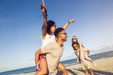 İki genç erkek arkadaşlarını omzunda sürmek veren