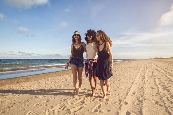 Üç güzel genç kadın Sahilde yürüyüş grubu