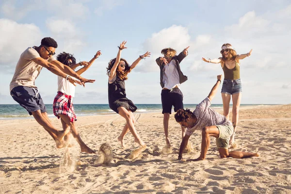 Щасливі молоді люди стрибають на пляжі — стокове фото