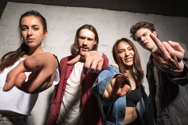 Gri arka plan üzerinde duran kızgın hipsters arkadaşlar