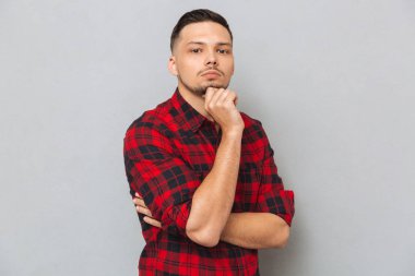 düşünceli genç adam kameraya bakan.