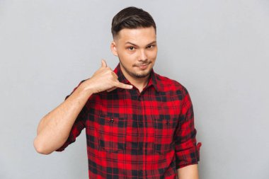 Tişörtlü telefon işaret gösteren genç adam