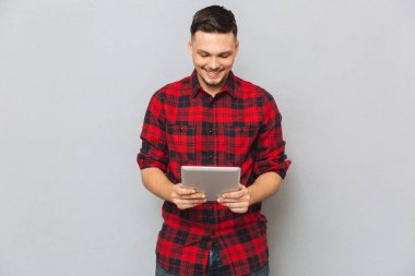 Tablet bilgisayar kullanan gülümseyen adam