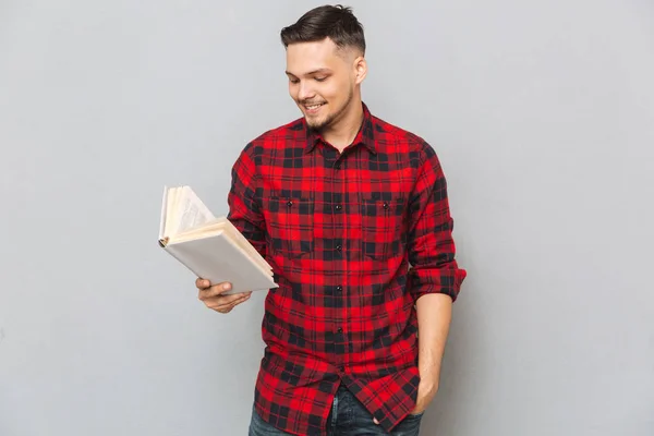 Hombre sonriente leyendo libro en estudio —  Fotos de Stock