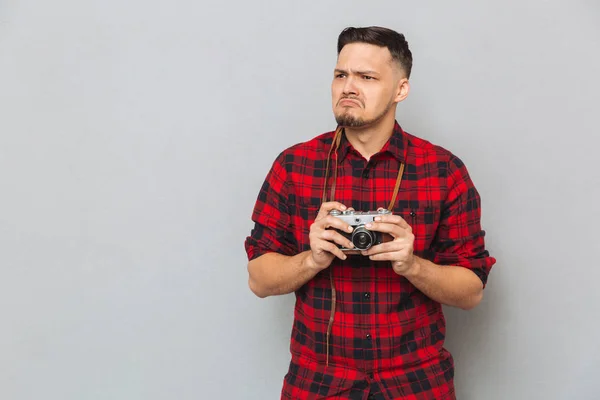 Mężczyzna niezadowolony w koszuli, trzymając aparat retro — Zdjęcie stockowe