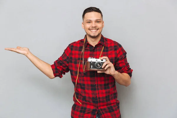 Uśmiechnięty mężczyzna trzyma miejsce na Funt i kamera retro — Zdjęcie stockowe