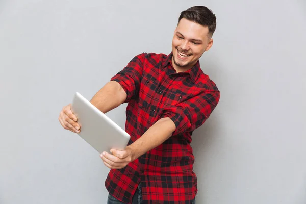 Sonriente hombre jugando en la tableta — Foto de Stock