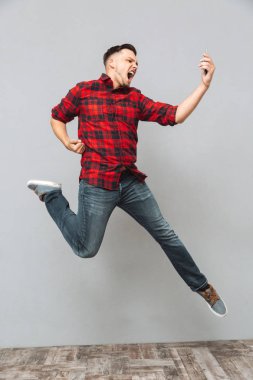 Genç adam cep telefonu yapmak kazanan hareketini kullanarak çığlık.