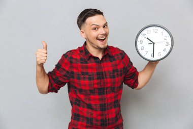 Mutlu adam saat ve gösteren başparmak gidiyor