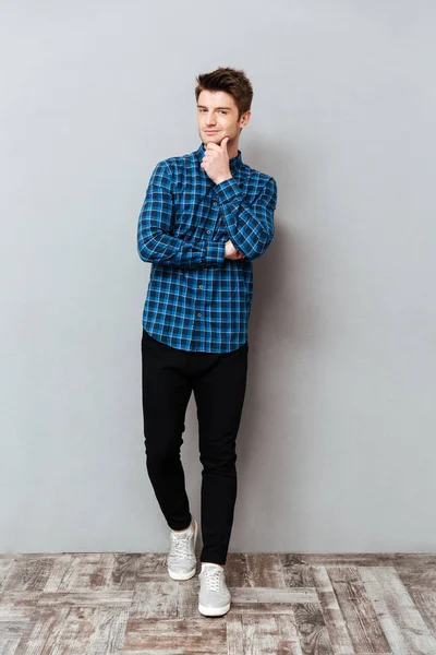 Stilig ung man står över grå vägg och poserar — Stockfoto