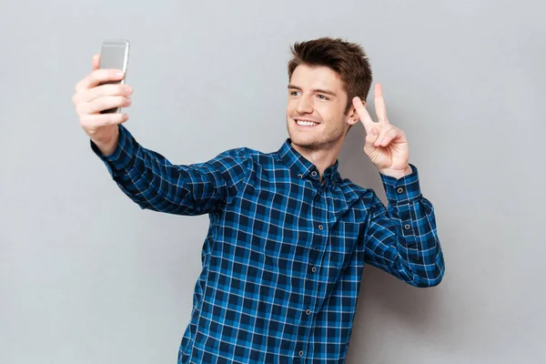 Joven haciendo selfie usando smartphone — Foto de Stock