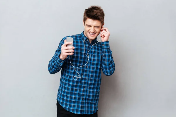 Junge Studentin genießt Musik im Kopfhörer auf Smartphone — Stockfoto