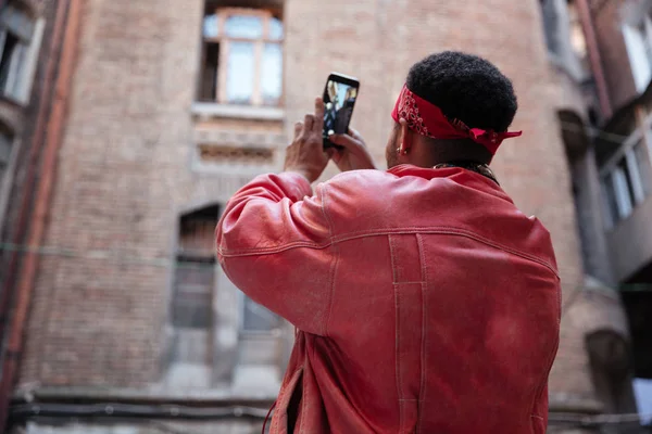 Killen i läder jacka att ta bild med mobiltelefon — Stockfoto