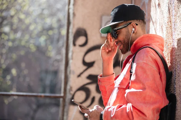 Feliz hombre afro americano con estilo en gafas de sol escuchando música —  Fotos de Stock