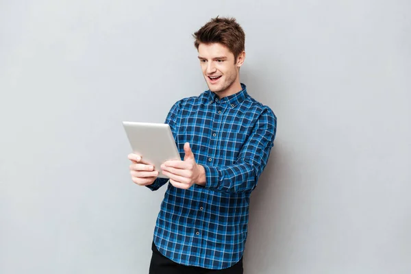 Verrast man kijken naar tablet pc geïsoleerd — Stockfoto