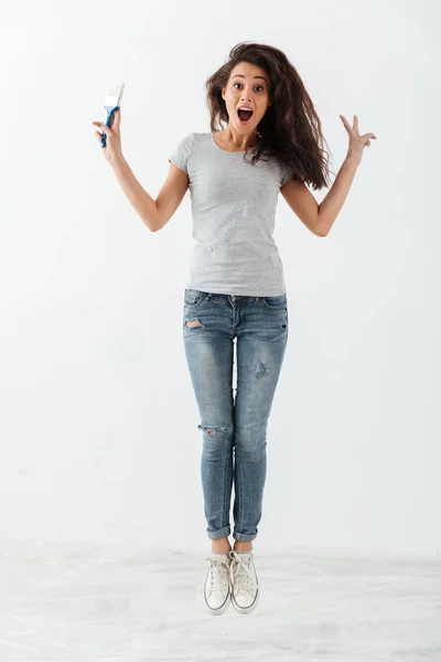 Pleine longueur de jeune femme mignonne surprise avec saut de brosse — Photo