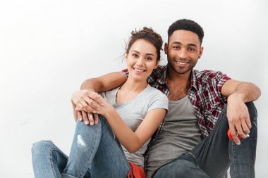 Oturma ve sarılma güzel çok ırklı genç çift gülümseyen