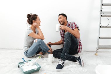 Genç sevgili çift kat yeni dairede oturan gülümseyen