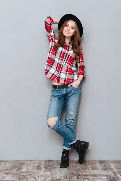 Mujer elegante sonriente en camisa a cuadros de pie y posando — Foto de Stock