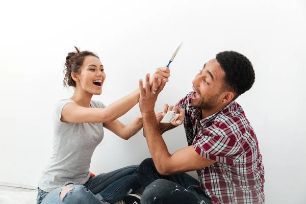 Feliz jovem casal amoroso sentado no chão em novo apartamento — Fotografia de Stock