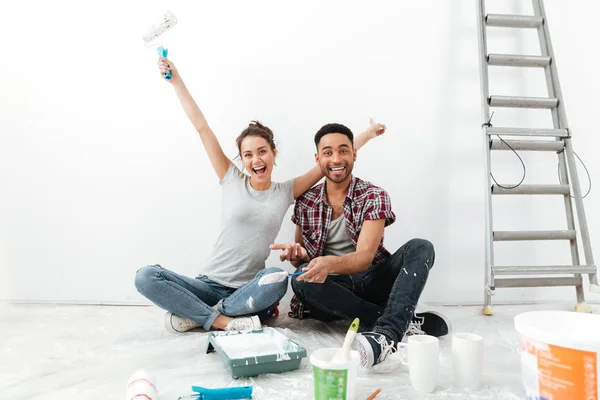 Feliz casal amoroso no chão em novo apartamento faz reparação . — Fotografia de Stock