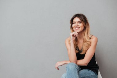 Mutlu genç kız bir sandalyede oturan ve poz
